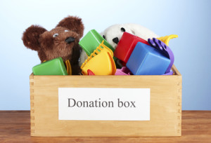 Donation box with children toys on blue background close-up